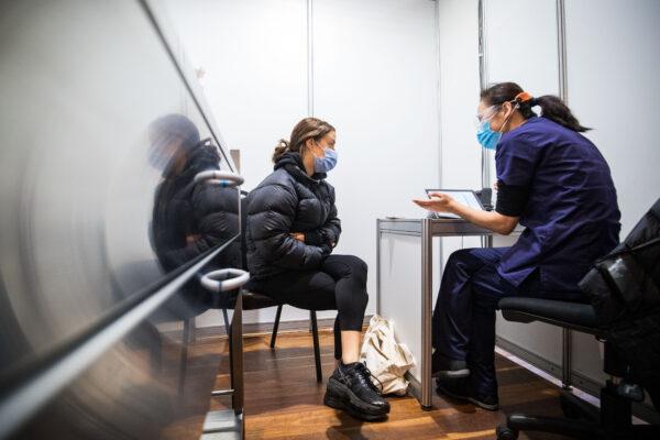 A nurse explains to a woman the vaccination process at the Royal Exhibition Building COVID-19 Vaccination Centre in Melbourne, Australia, on May 28, 2021. (Darrian Traynor/Getty Images)