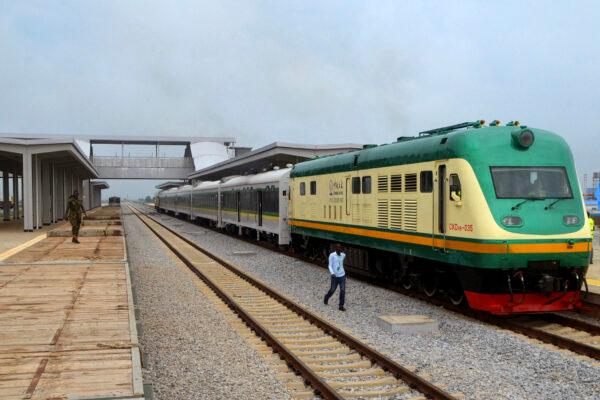 A man walks past a train on the newly completed Abuja–Kaduna railway line in Abuja, on July 21, 2016. On March 28, a train carrying close to 1,000 passengers was bombed by bandits who killed eight people and kidnapped several others. (Stringer/AFP via Getty Images)