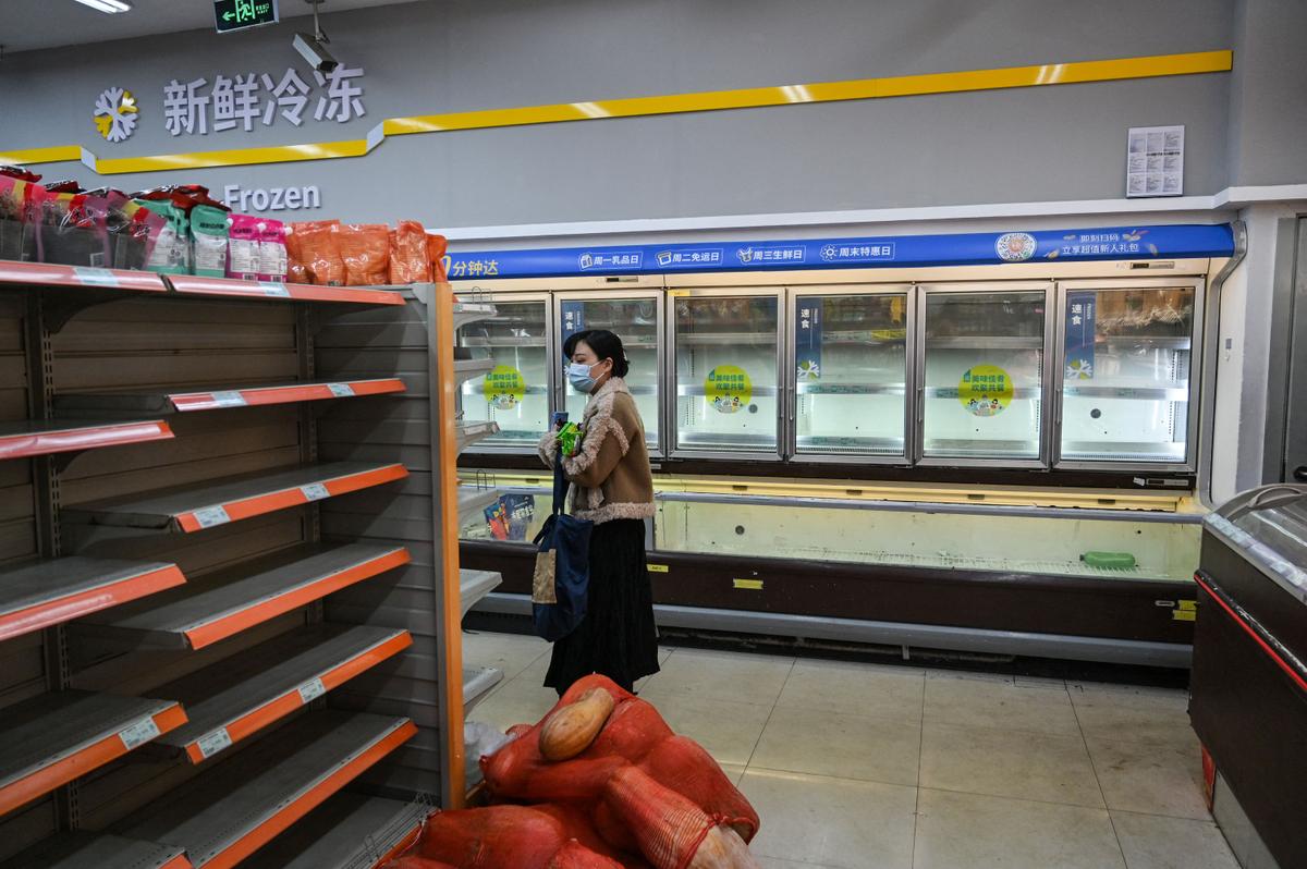 Shoppers rummage through empty shelves in a supermarket before a lockdown as a measure against the Covid-19 coronavirus in Shanghai on March 29, 2022. (Hector Retamal/AFP via Getty Images)