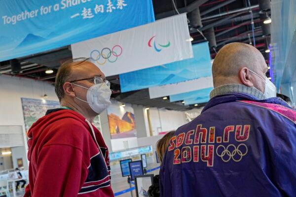 A Russian new agency journalist wearing the Sochi Winter Olympic jacket as he line up with his colleague outside a store selling official Olympics memorabilia ahead of the 2022 Winter Paralympics at the Main Media Center in Beijing, on March 2, 2022. (Andy Wong/AP Photo)