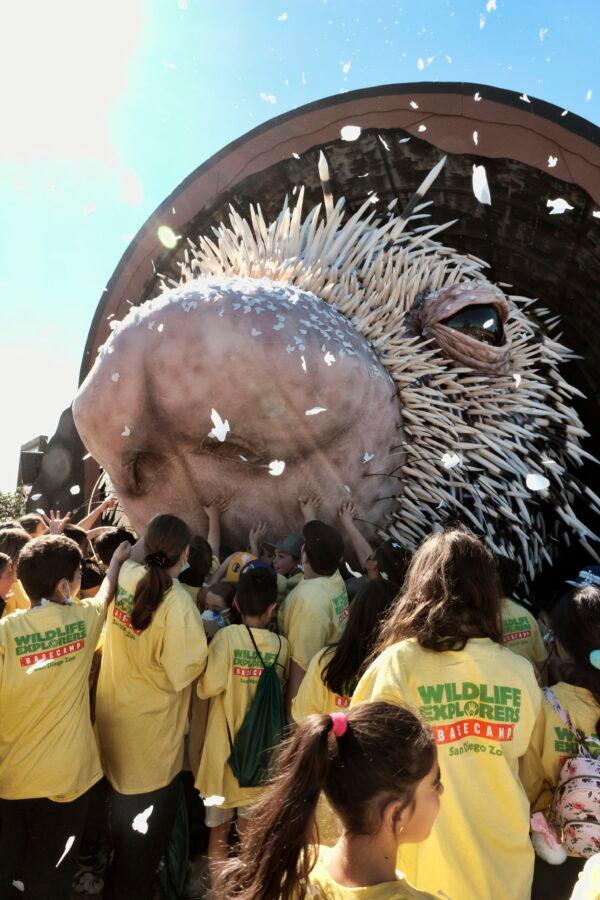 Los Angeles school children reach out to touch a giant puppet porcupine named Percy at Elysian Park in Los Angeles on March 1, 2022. (Richard Vogel/AP Photo)