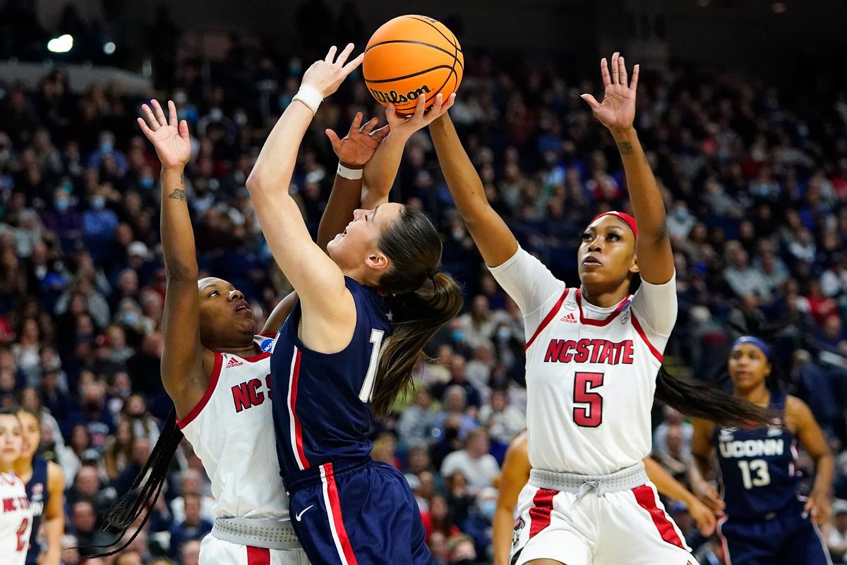Connecticut guard Nika Muhl (10) puts up a shot against NC State guard Diamond Johnson (L), and forward Jada Boyd (5) during the second quarter of the East Regional final college basketball game of the NCAA women's tournament in Bridgeport, Conn., on March 28, 2022. (Frank Franklin II/AP Photo)