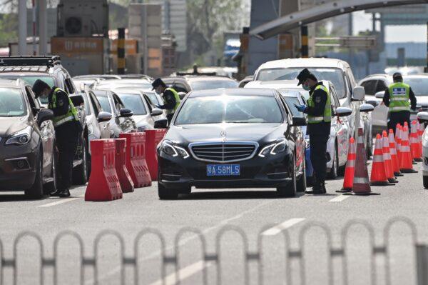 Police officers check drivers at a checkpoint before they enter Wuhan, in China's central Hubei Province on April 6, 2020. (HECTOR RETAMAL/AFP via Getty Images)