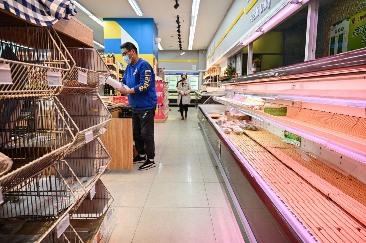 Shoppers amid empty shelves in a supermarket before a lockdown as a measure against COVID-19 in Shanghai on March 29, 2022. (Hector Retamal/AFP via Getty Images)