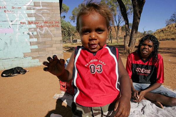 Indigenous 1-year-old child Willy (L) and sister Lucia (R) play at the family's house in 'Hidden Valley', which is one of the "town camps" around Alice Springs, 18 May 2007. (ANOEK DE GROOT/AFP via Getty Images)