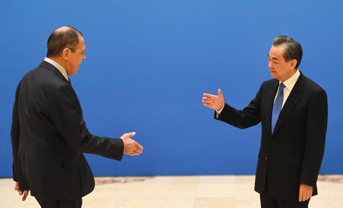 Russian Foreign Minister Sergei Lavrov (L) moves to shake hands with Chinese State Councilor and Foreign Minister Wang Yi before a meeting of foreign ministers and officials of the Shanghai Cooperation Organization (SCO) at the Diaoyutai State Guest House in Beijing, China, on April 24, 2018. (Madoka Ikegami/Pool/Getty Images)