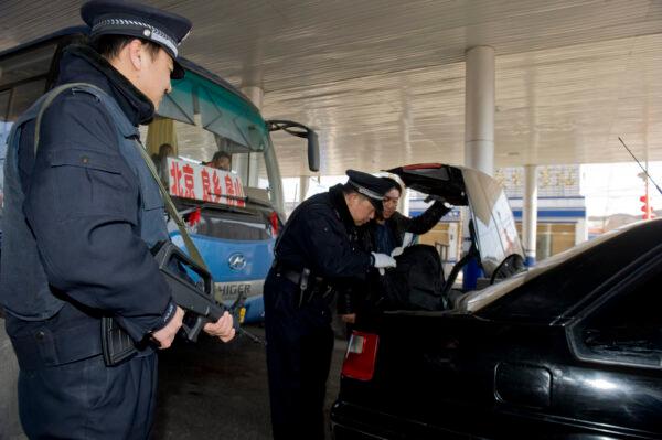 Chinese police search the booth of a car at a checkpoint along a highway into Beijing, China, on March 2, 2010. (STR/AFP via Getty Images)