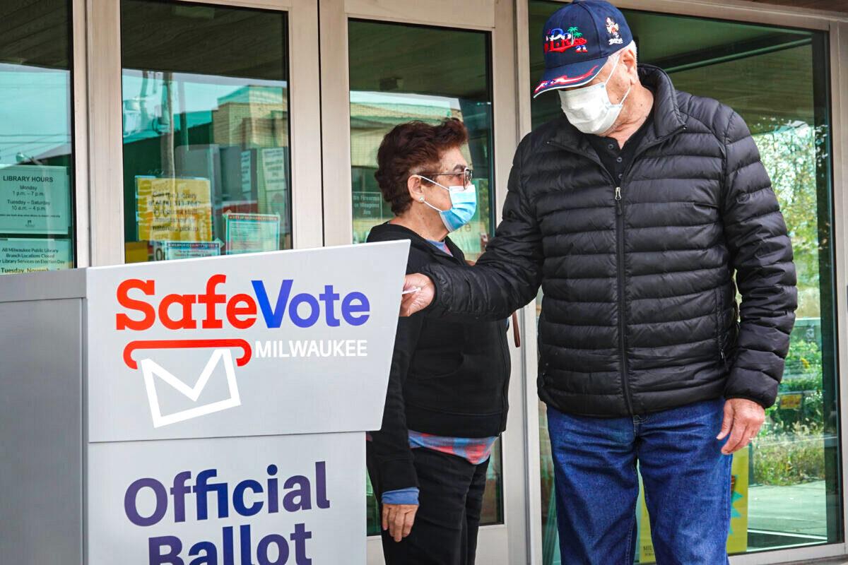 Residents drop mail-in ballots into a ballot box outside a Tippecanoe library branch in Milwaukee on Oct. 20, 2020. (Scott Olson/Getty Images)