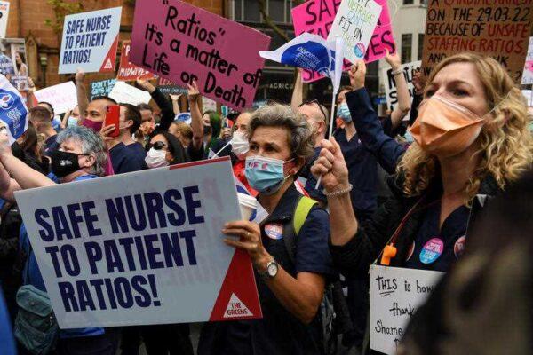 Nurses and midwives hold placards during a nurses’ strike rally at NSW Parliament House in Sydney, Thursday, March 31, 2022. (AAP Image/Bianca De Marchi)