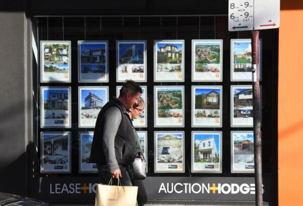 A couple walks past a real estate agent's window advertising houses for sale and auction in Melbourne, Australia, on May 1, 2019. (William West/AFP via Getty Images)