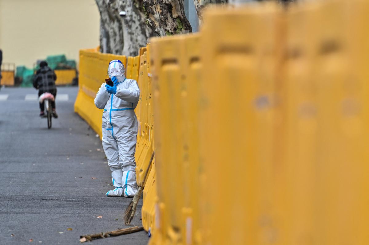 A worker wearing a protective gear stands next to barriers during lockdown in Jing'an district, in Shanghai on March 31, 2022. (Hector Retamal/AFP via Getty Images)