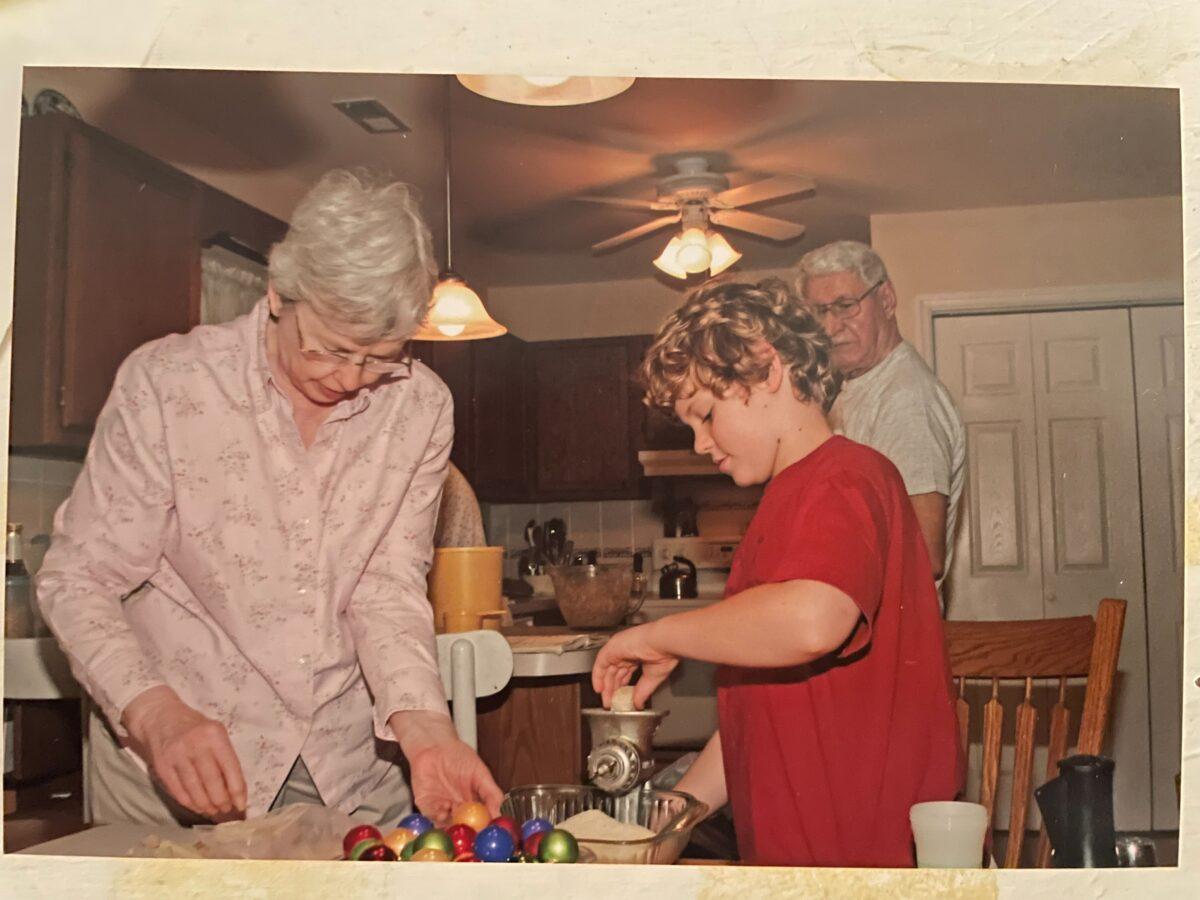 The author's son, Trenton, grinds walnuts while his grandparents supervise. The nut grinder belonged to the author's maternal grandmother.  (Courtesy of Mary Lou Young)