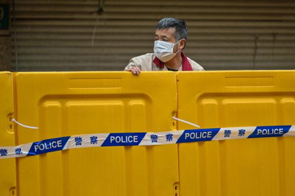 A man stands behind barriers during lockdown in Jing'an district in Shanghai on March 31, 2022. (Hector Retamal/AFP via Getty Images)