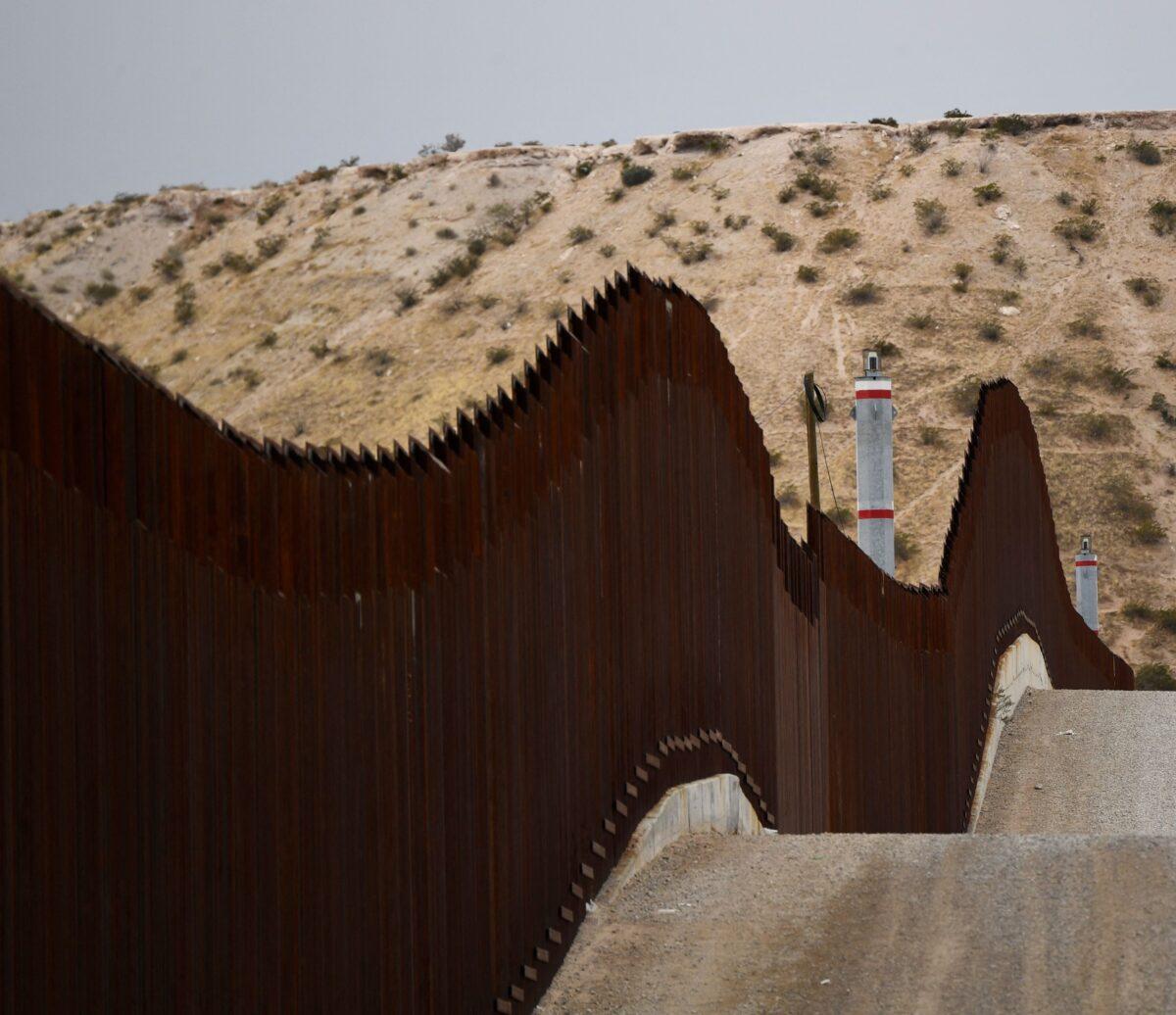 A U.S. Border Patrol vehicle sits next to a border wall in the El Paso Sector along the U.S.-Mexico border between New Mexico and Chihuahua state, in Sunland Park, New Mexico, on Dec. 9, 2021. (Patrick T. Fallon/AFP via Getty Images)