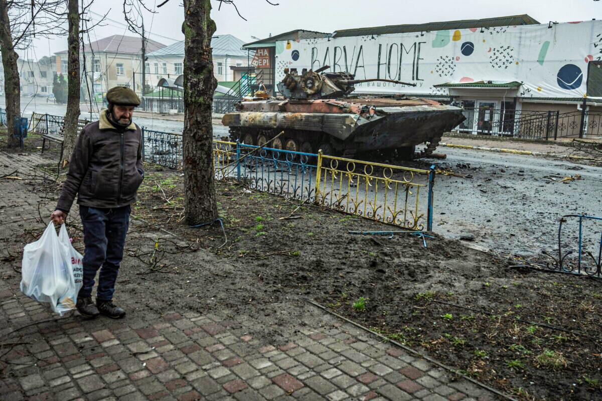 A local man walks past a damaged armored personal carrier, as Russia's attack on Ukraine continues, in the town of Makariv, in the Kyiv region of Ukraine, on April 1, 2022. (Serhii Mykhalchuk/Reuters)