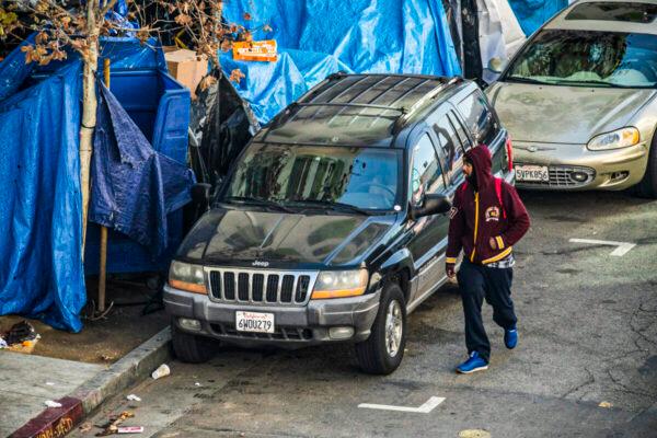 A man walks past a homeless encampment in Los Angeles, on Jan 6, 2022. (John Fredricks/The Epoch Times)