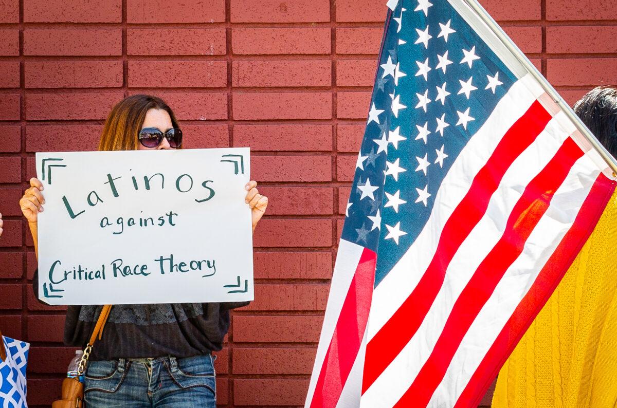 A woman holds a sign discouraging critical race theory in Los Alamitos, Calif., on May 11, 2021. (John Fredricks/The Epoch Times)