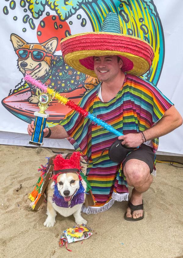 Kyle James poses with his corgi, Cricket, after winning the Best Costume Contest at the 10th Annual Corgi Beach Day in Huntington Beach on April 2, 2022. (Carol Cassis/The Epoch Times)