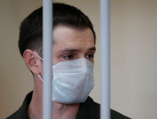 Former U.S. Marine Trevor Reed stands inside a defendants' cage during a court hearing in Moscow, on July 30, 2020. (Maxim Shemetov/Reuters)