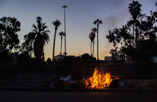 Fires lit within a homeless encampment fill the air with smoke in Los Angeles, Calif., on Jan. 2, 2022. (John Fredricks/The Epoch Times)