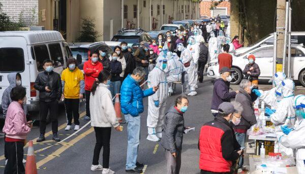 People at from a residential block line up to be swabbed during a citywide COVID-19 nucleic acid testing campaign on April 1, 2022 in Shanghai, China. (Zhang Suoqing/VCG via Getty Images)