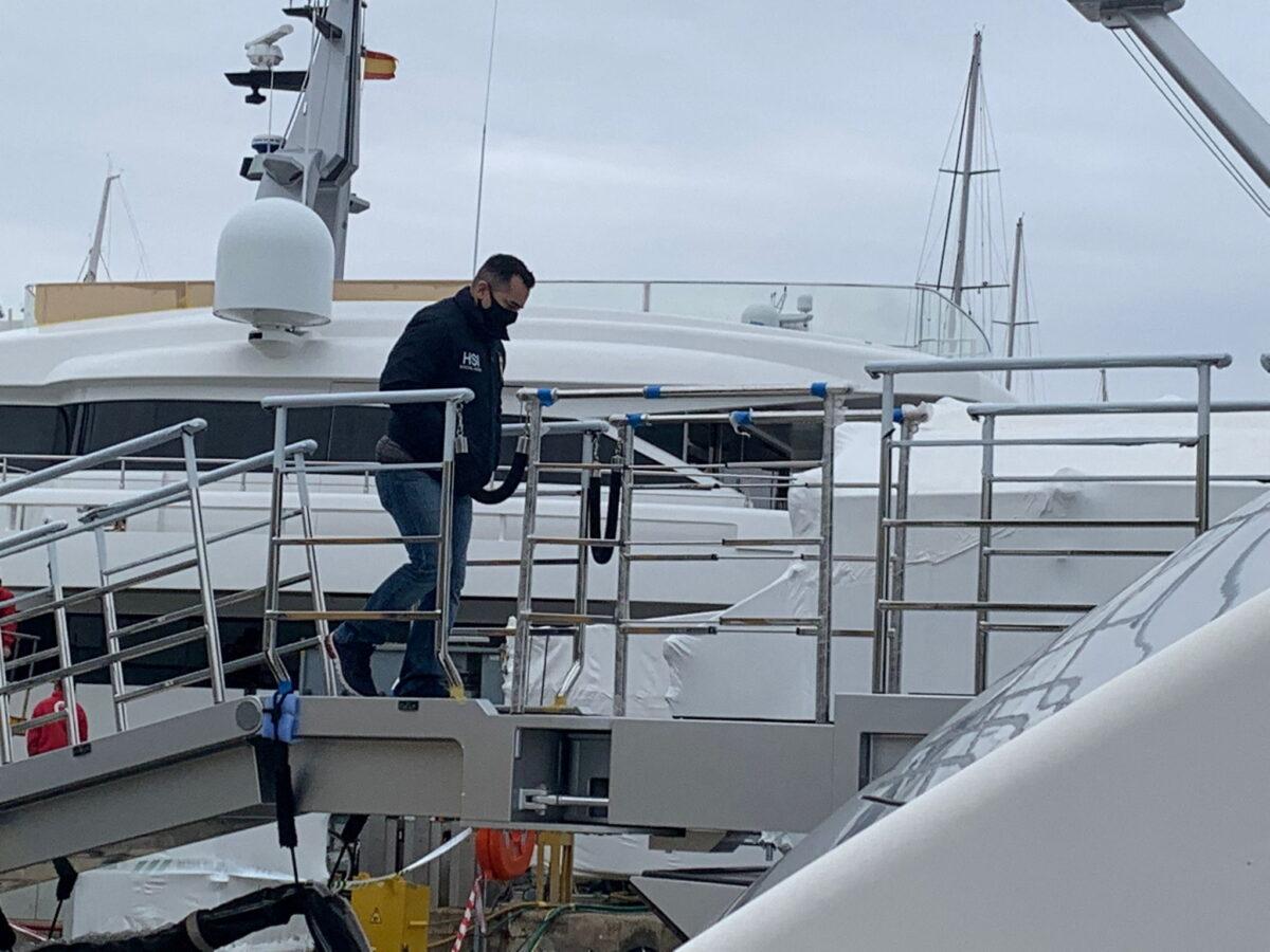A U.S. Homeland Security Police (HSI) agent climbs on board the "Tango" superyacht, suspected to belong to a Russian oligarch, as it is docked at the Mallorca Royal Nautical Club in Palma de Mallorca, in the Spanish island of Mallorca, Spain, on April 4, 2022. (Juan Poyates Oliver/Handout via Reuters)