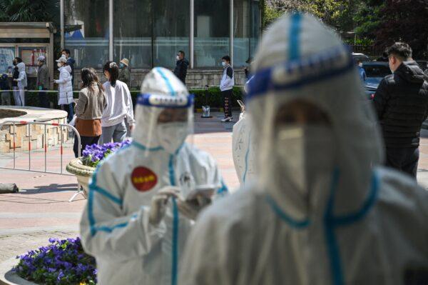 Residents wait in line to be tested for the COVID-19 coronavirus during the second stage of a pandemic lockdown in Jing'an, a district in Shanghai, on April 4, 2022. (Hector Retamal/AFP via Getty Images)