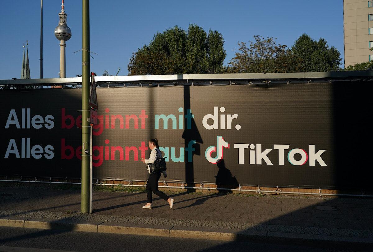 A young woman using a cellphone walks past an advertisement for social media company TikTok on Sept. 21, 2020 in Berlin, Germany. (Sean Gallup/Getty Images)