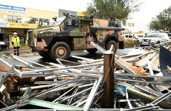An army vehicle drives past debris in the flood-affected city centre in Lismore, Australia, on March 29, 2022. (Dan Peled/Getty Images)