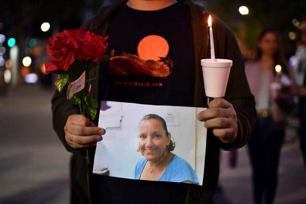 A person who did not want to be identified holds a photograph of Melinda Davis, 57, during a candlelight vigil held at Ali Youssefi Square in Sacramento, Calif., on April 4, 2022. (Jose Carlos Fajardo/Bay Area News Group via AP)