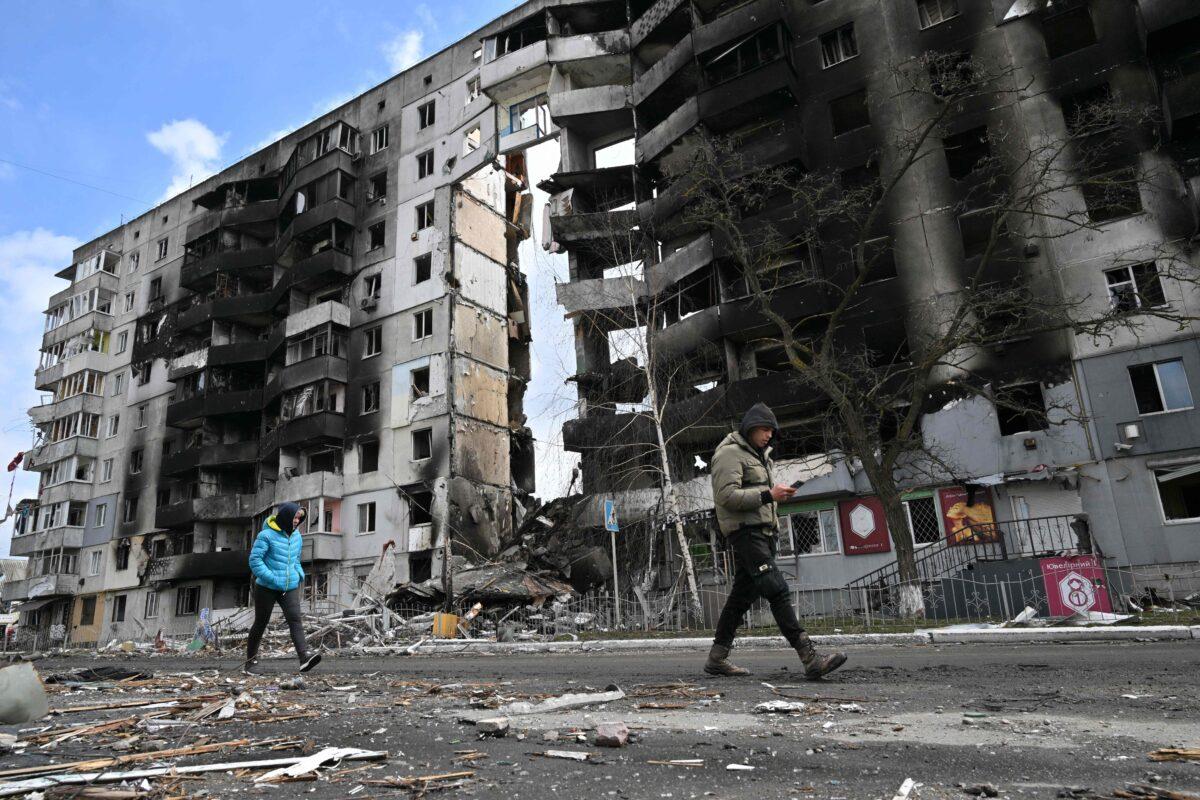 People walk past destroyed buildings in the town of Borodianka, northwest of Kyiv, on April 4, 2022.  (Sergei Supinsky/AFP via Getty Images)