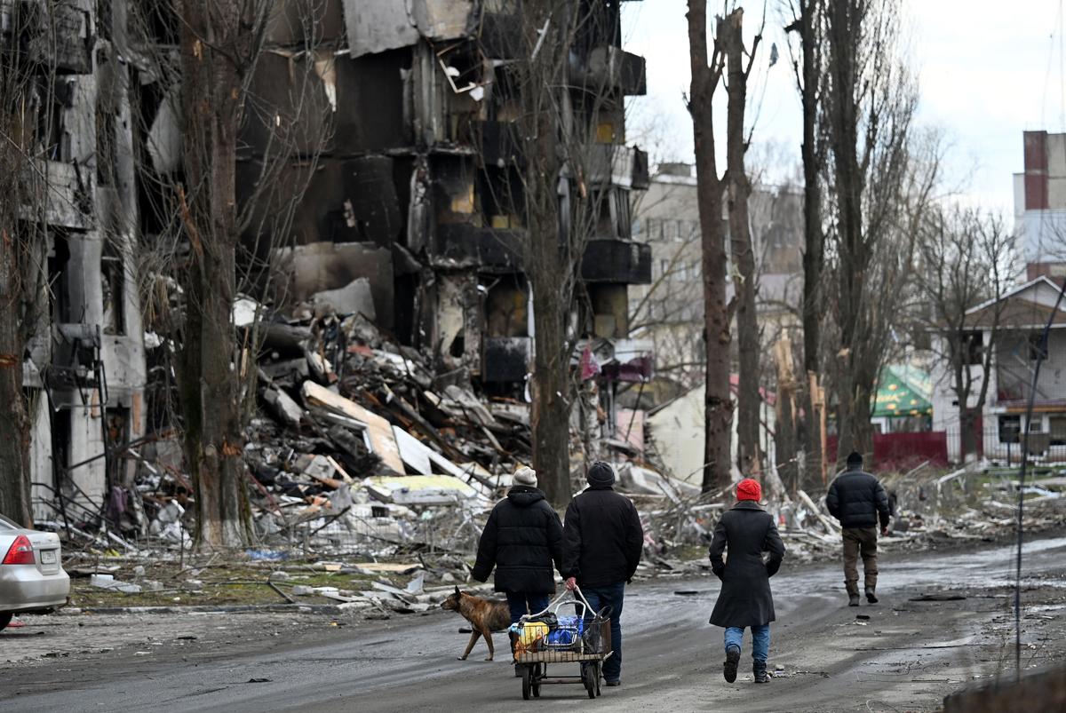 People walk past destroyed buildings in the town of Borodianka, northwest of Kyiv, on April 4, 2022. (Sergei Supinsky/AFP via Getty Images)