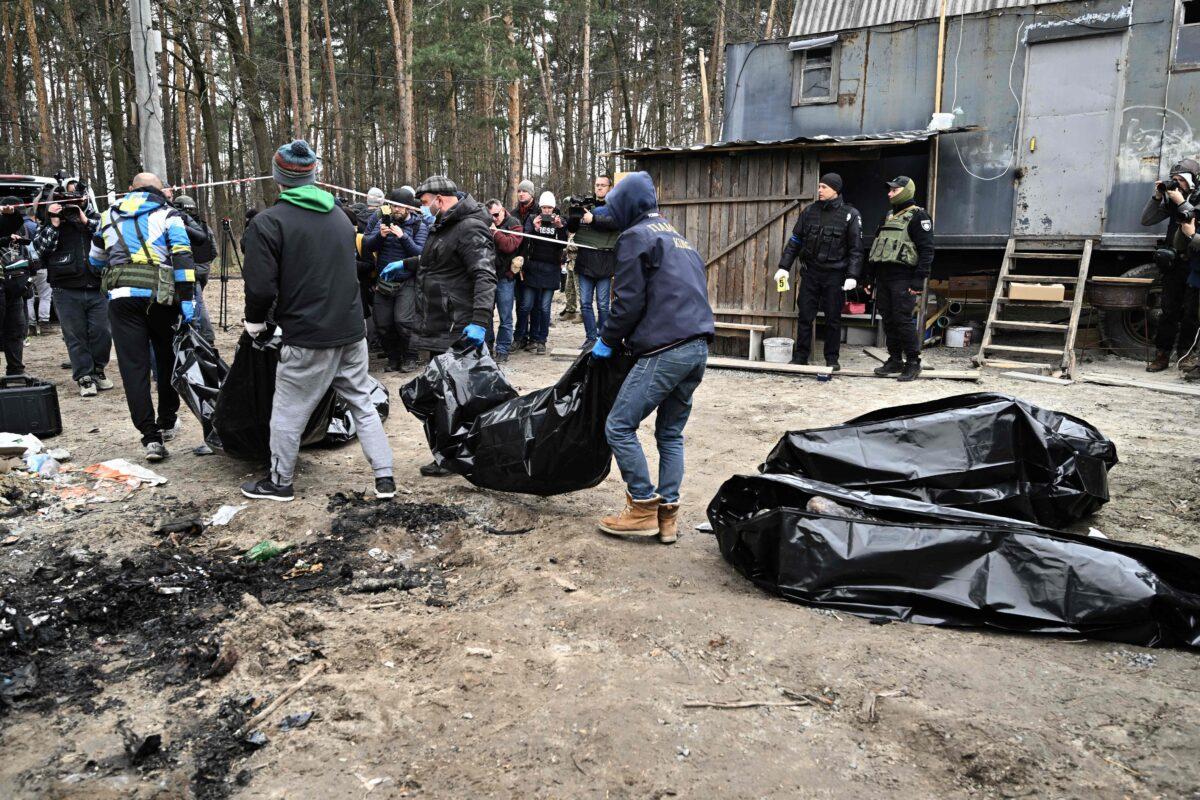 City workers carry body bags with six partially burnt bodies found in the town of Bucha, Ukraine, on April 5, 2022. (Genya Savilov/AFP/Getty Images)