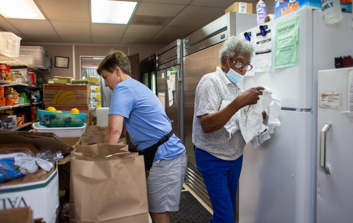 Volunteers Tami Greene (L) and Gloria Banks (R) work in the food pantry ministry building at Friendship Baptist Church in Yorba Linda, Calif., on April 5, 2022. (John Fredricks/The Epoch Times)