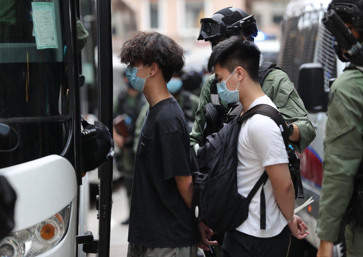 Police officers escort men into a police van following a pro-democracy protest in Hong Kong on Oct. 1, 2020. (May James/AFP via Getty Images)