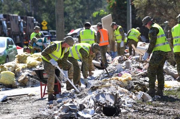 Members of the Australian Defence Force are seen helping in the clean up of flood affected properties in Goodna of Queensland, Australia, on March 8, 2022. The state is looking at a $2.5 billion damage bill from the flooding that claimed 13 lives. (AAP Image/Darren England)