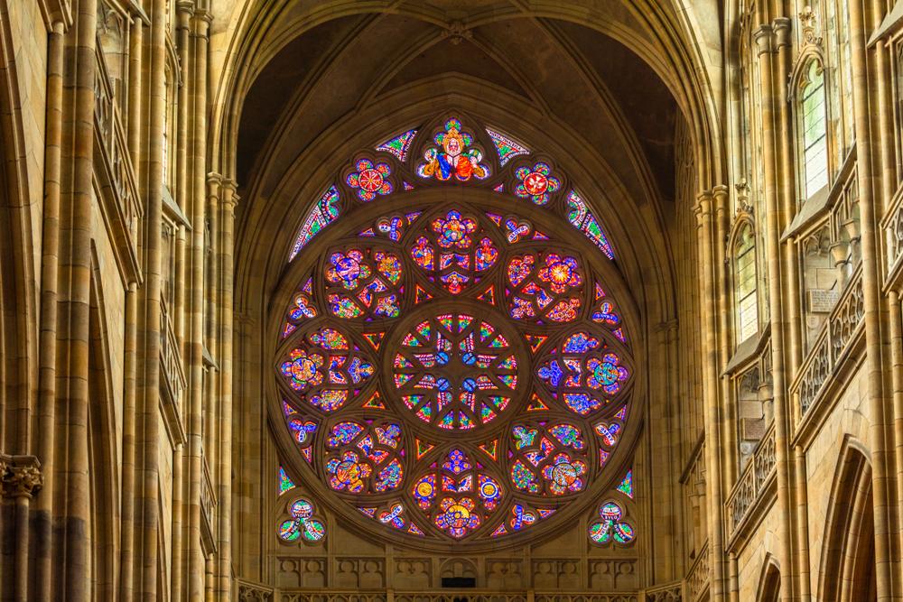 Created by Frantisek Kysela in 1925, the rose window on the main west-facing façade forms a radiating pattern of eight petals. Filled with colorful geometric-shaped stained glass, the form is a beautiful centerpiece for the nave that glows in the afternoon sun. The inscriptions on the stained glass tell the story of creation as told in the Bible. (Romas-Vysniauskas/Shutterstock)