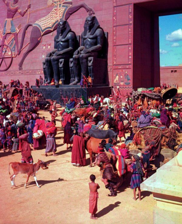 A shot with extras dressed in bright colors against the imposing set. (Cecil B. DeMille Foundation ©2022)