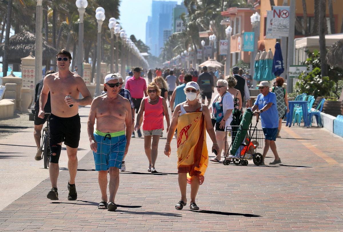 People walk on the Broadwalk on Hollywood Beach on Thursday, February 3 2022. There are lots of benches for resting and cafes for feeling the breeze, or take a walk right on the beach and let the sand tickle your toes. (Mike Stocker/South Florida Sun-Sentinel/TNS)
