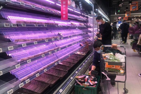 Customers look through empty shelves at a supermarket in Shanghai, on March 30, 2022. (Chen Si/AP Photo)