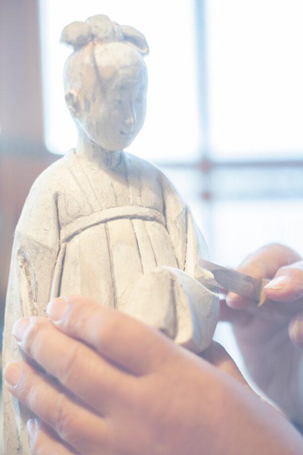 Japanese doll maker Komao Hayashi carves a toso doll using 17th-century techniques that include making a modeling paste made from the sawdust of the paulownia tree. “Komao Hayashi, from 'The Ateliers of Wonders Series, 2020,'” by Rinko Kawauchi. (Rinko Kawauchi/Michelangelo Foundation)