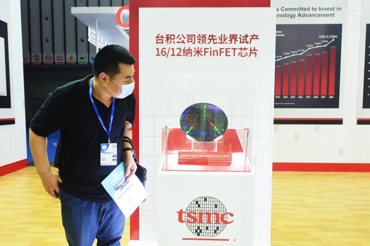 A visitor looks at a 300mm wafer at the booth of Taiwan Semiconductor Manufacturing Company Limited (TSMC) during the 2021 World Semiconductor Conference in Nanjing, Jiangsu Province, China, on June 9, 2021. (Long Wei/VCG via Getty Images)