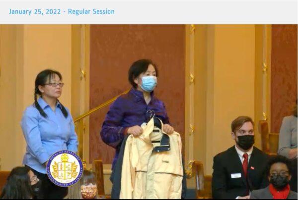 Wang Chunyan shows the slave labor-produced jacket she smuggled out of Liaoning Women's Prison in northeastern China when she spoke to members of the Virginia General Assembly during a regular session in Richmond, Va., on Jan. 25, 2022. (Screenshot via The Epoch Times)