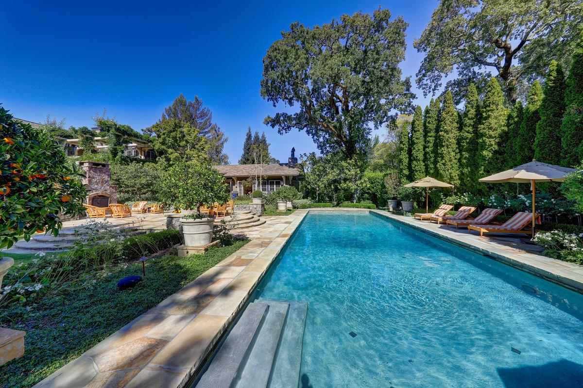 A stunning, 60-foot swimming pool is the center of outside activity. There’s also a BBQ and outdoor fireplace, and myriad picnic and al fresco dining spots. Surrounded by woods, the estate is a literal hidden paradise. (Courtesy of Jason Wells Photography and Golden Gate Creative/Tracy McLaughlin)