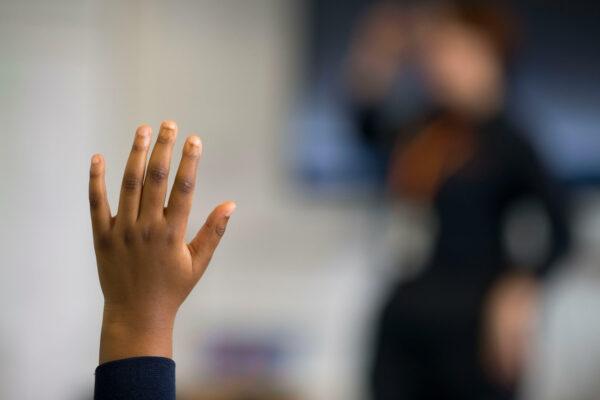 A pupil raises their hand during a lesson at Whitchurch High School in Cardiff, Wales, on Sept. 14, 2021. (Matthew Horwood/Getty Images)