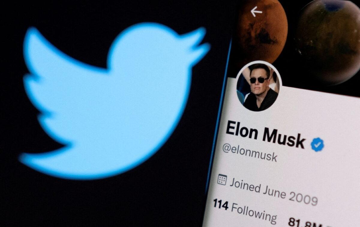 Elon Musk's Twitter account is seen on a smartphone in front of the Twitter logo, on April 15, 2022. (Dado Ruvic/Reuters)