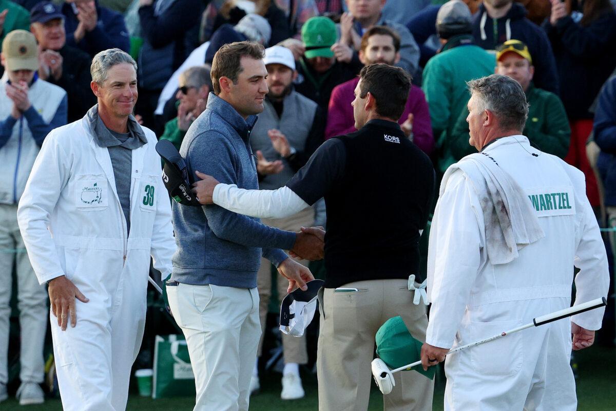 Scottie Scheffler (L) and Charl Schwartzel of South Africa shake hands on the 18th green after finishing their round during the third round of the Masters at Augusta National Golf Club, in Augusta, Georgia, on April 9, 2022. (Andrew Redington/Getty Images)