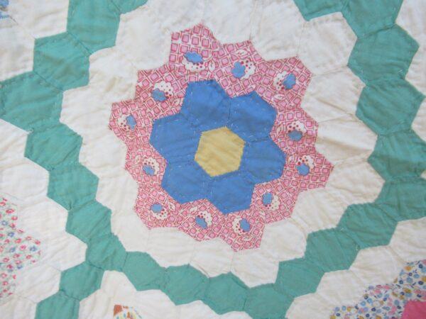 The author’s grandmother’s Flower Garden quilt that was constructed using chicken linen fabrics. (Nancy E. Whiting)