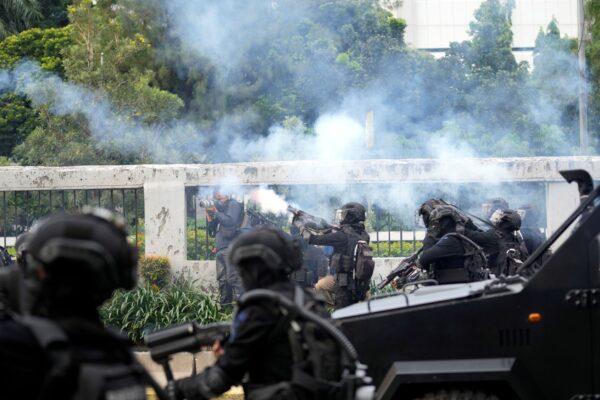 Police fire tear gas to disperse protesters during a rally in Jakarta, Indonesia, on April 11, 2022. (Tatan Syuflana/AP Photo)