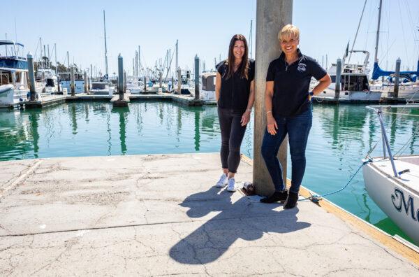 Donna Kalez (L) and Giselle Anderson stand on a dock in Dana Point Harbor, Calif., on April 7, 2022. (John Fredricks/The Epoch Times)